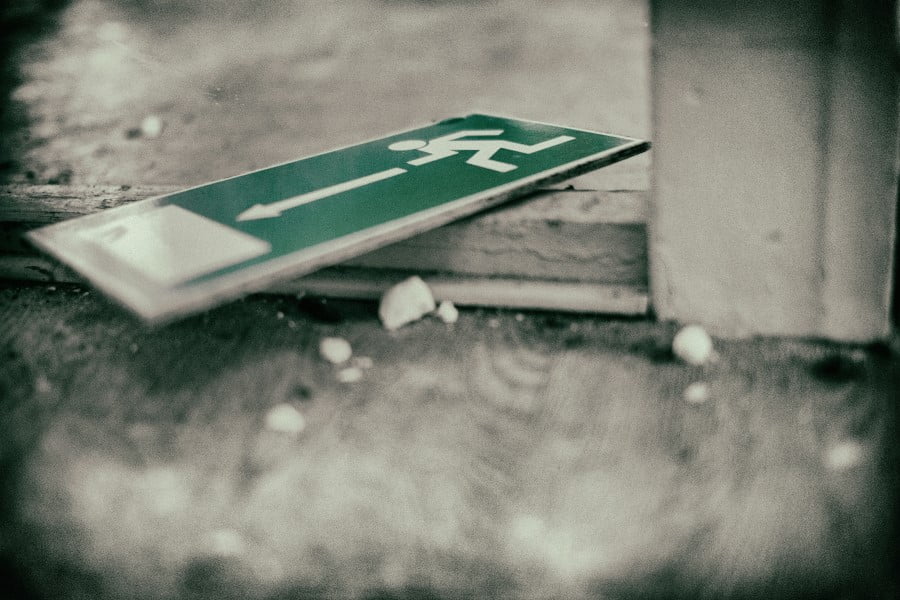 a green sign on a wooden surface