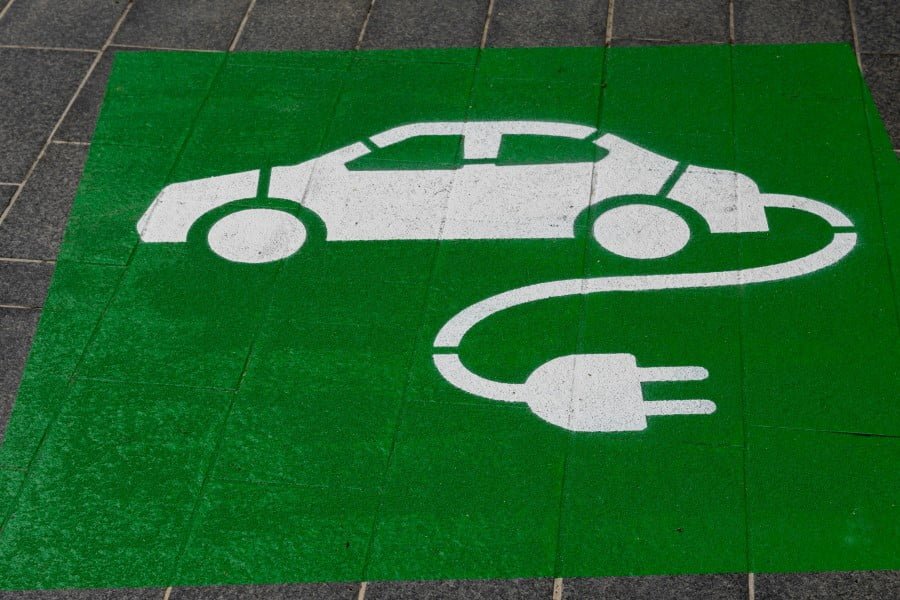 a green and white painted sign on a sidewalk