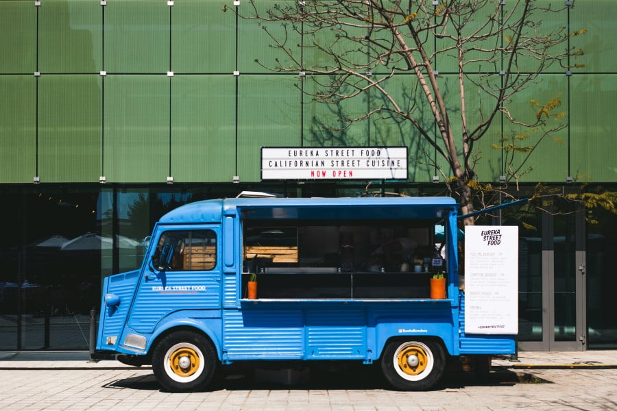 a blue food truck parked in front of a building