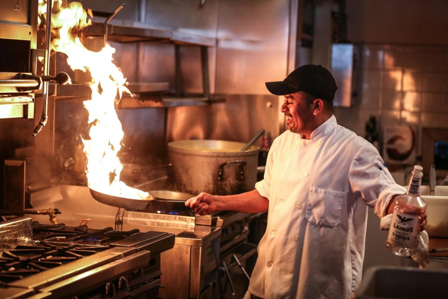 a man in a kitchen with a fire