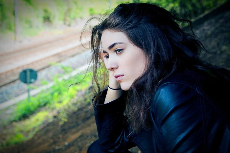 a woman sitting on a train track