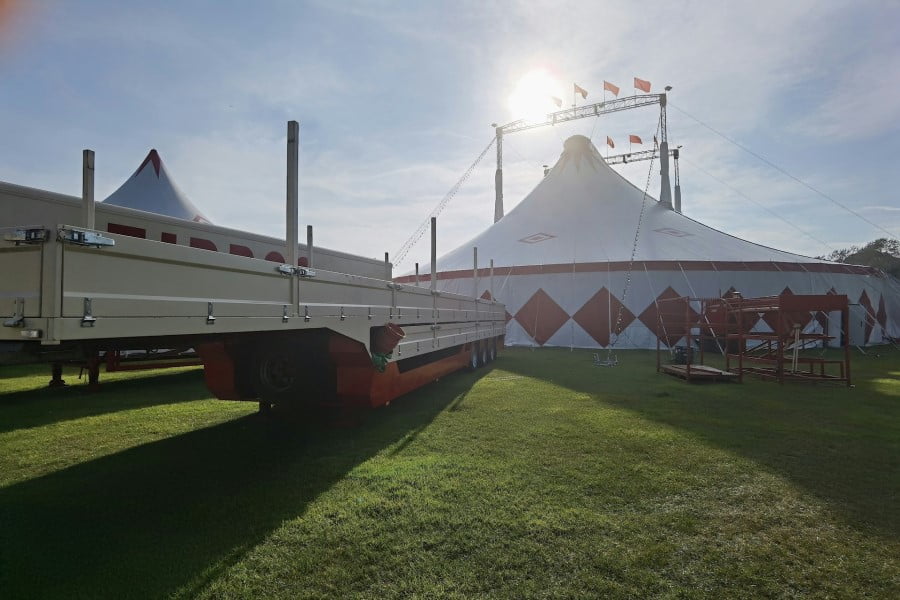 a white tent with a trailer parked on grass