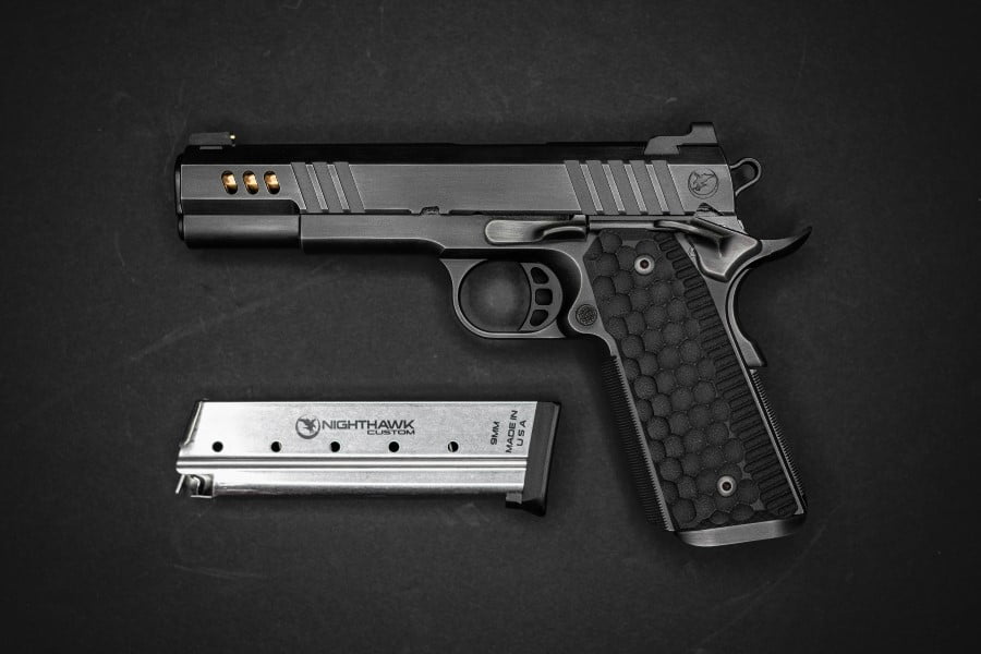 a gun and magazine on a black surface