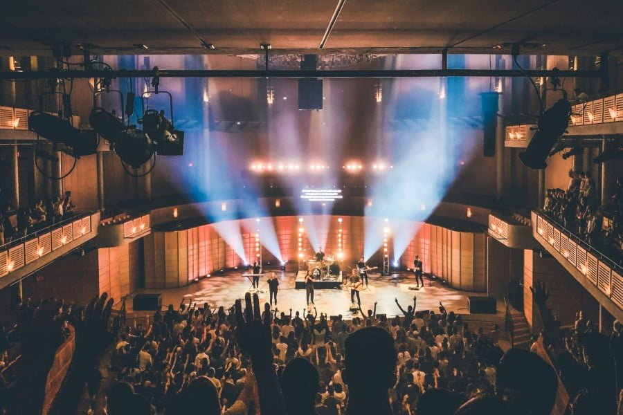 a band performing on a stage with a crowd of people