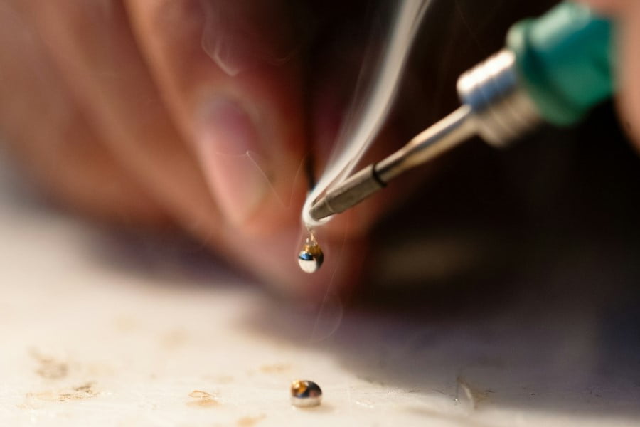 a hand holding a soldering iron
