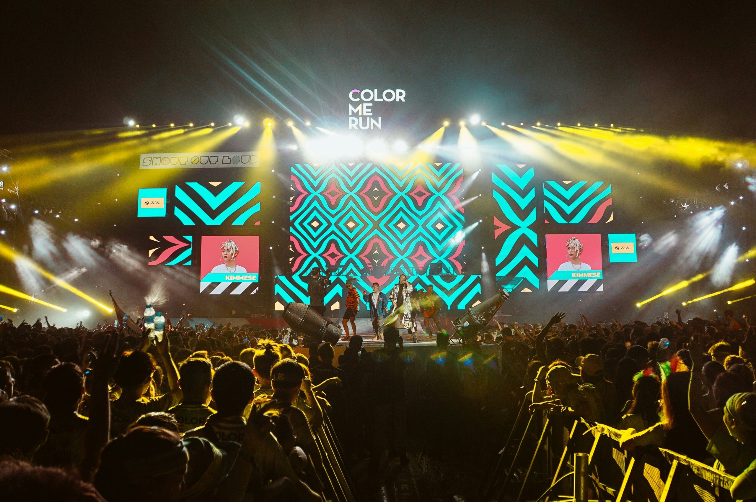 a group of people on a stage with a crowd of people in the background
